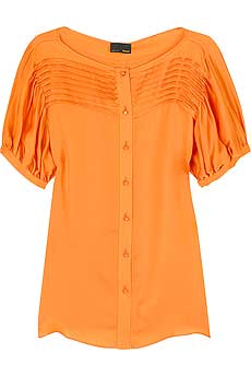 Orange silk blouse with pleated detail at the top.