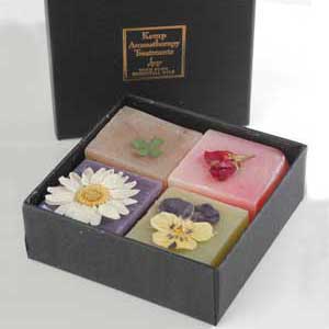 An aromatherapy gift pack of four travel-size soaps, beautifully packaged and decorated with rose