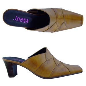 A backless court shoe from Jones Bootmaker. Features square toe, decorative panel work and a small e