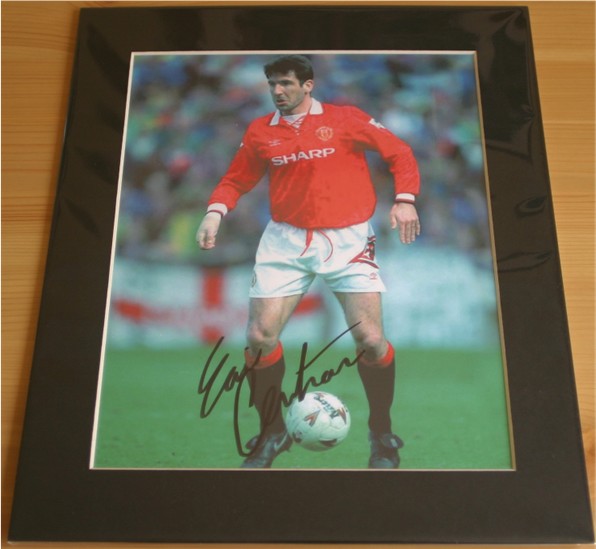 Eric Cantona has signed this superb photo in black pen. The item has been professionally mounted to