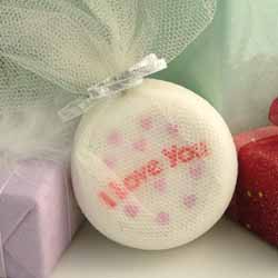 A luxury champagne scented bath bomb with `I Love You` attached in red.