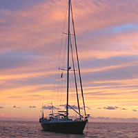 Set sail aboard a luxury yacht and witness the spectacular sight of the tropical sun setting into th