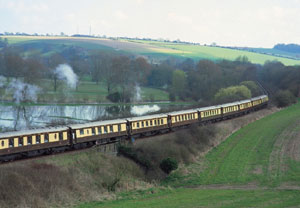 The gleaming carriages of the British Pullman wait as stewards, in their immaculate uniforms, welcom