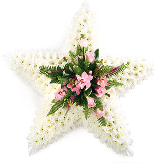 This massed star shaped tribute is subtle yet striking set off with a lovely pink spray in the centr