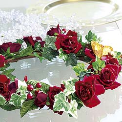 Deep red roses and ivy make up this delightful decoration adorned with a golden butterfly