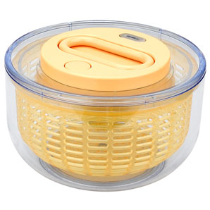A fast-moving yellow acrylic salad spinner with a transparent outer case and stop button. The