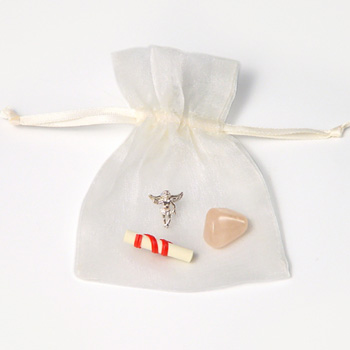 Inside this pouch is a silver Guardian Angel for protection, natural rose quartz for love and friend
